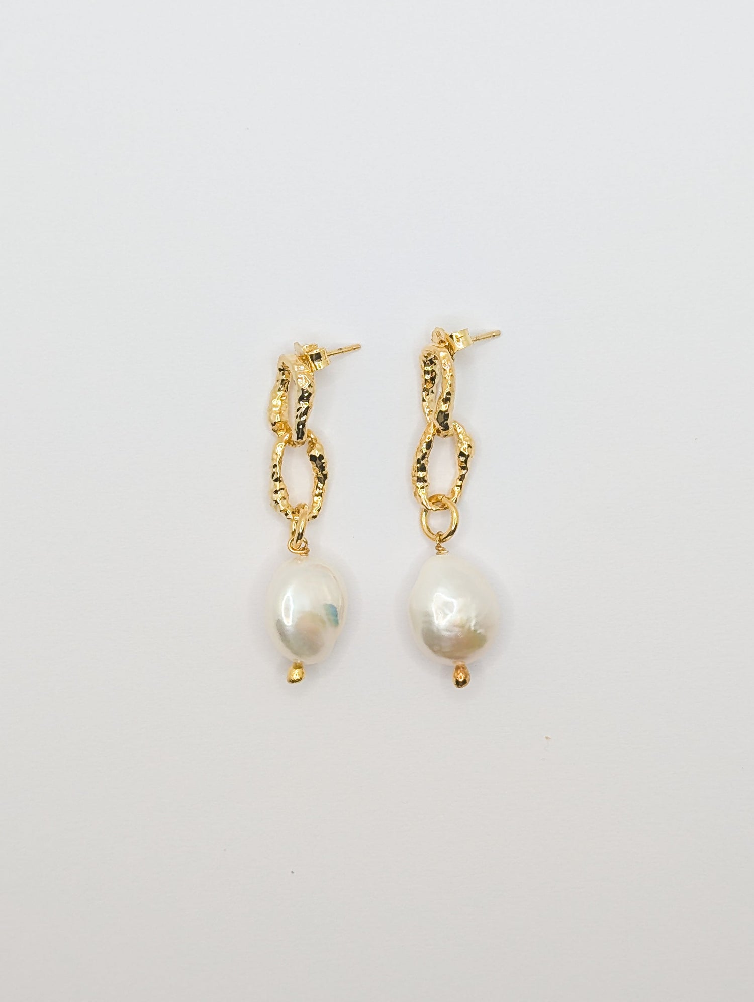 Pearl drop gold plated earrings on a white background