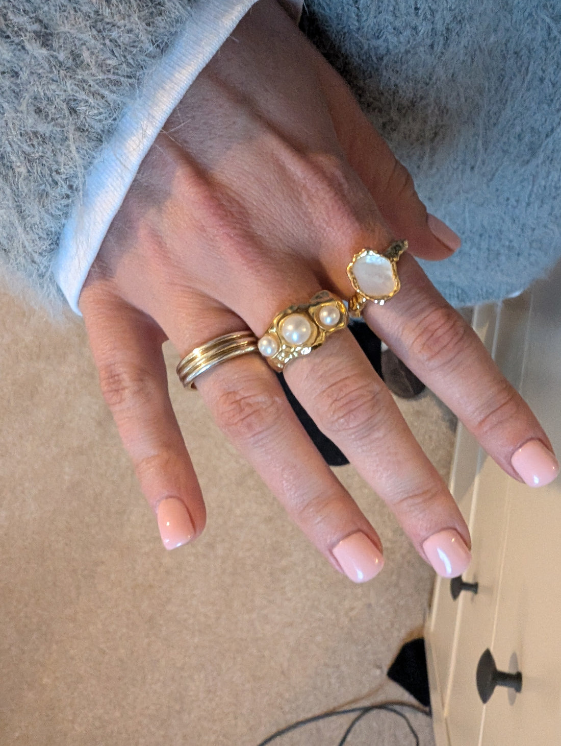 Close up of female hand with a collection of Another Mother rings on multiple fingers
